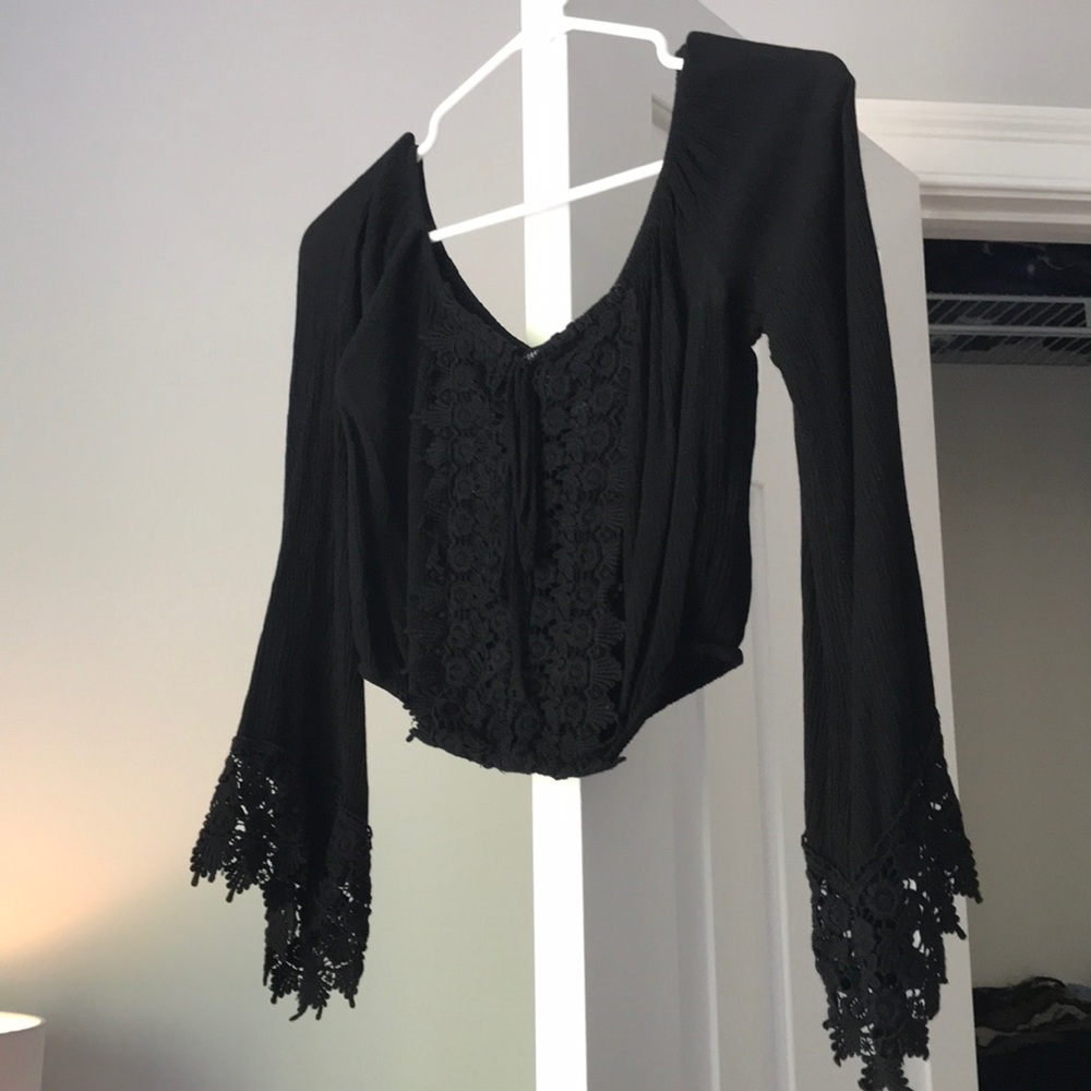 Black lace blouse wit flared long sleeves.